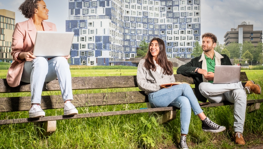 Studenten zitten buiten op een bankje voor het Johanna gebouw studentenhuisvesting SSH Utrecht Science Park