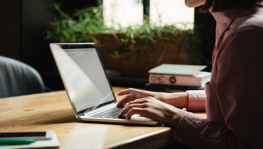 Cropped Side view of brunette woman sitting by the table