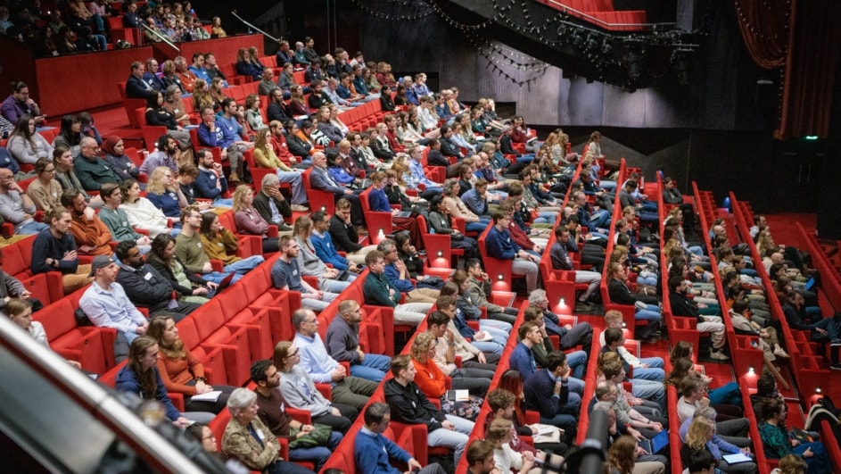 mensen zittend in een omhooglopende collegezaal